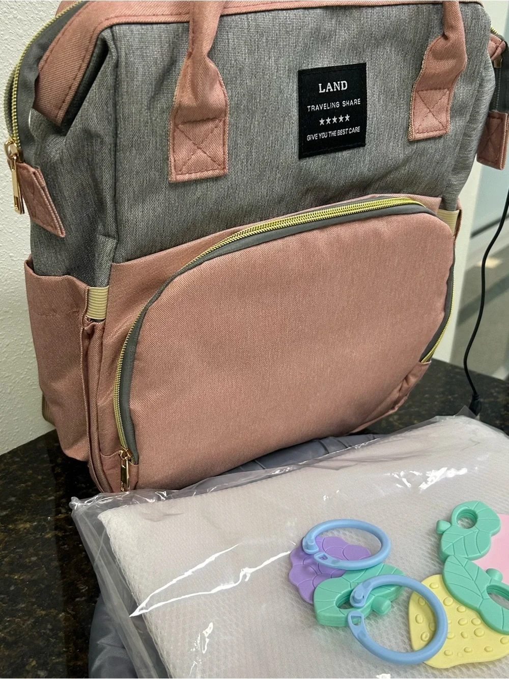 LAND Traveling Share diaper bag backpack in a pink and gray color scheme